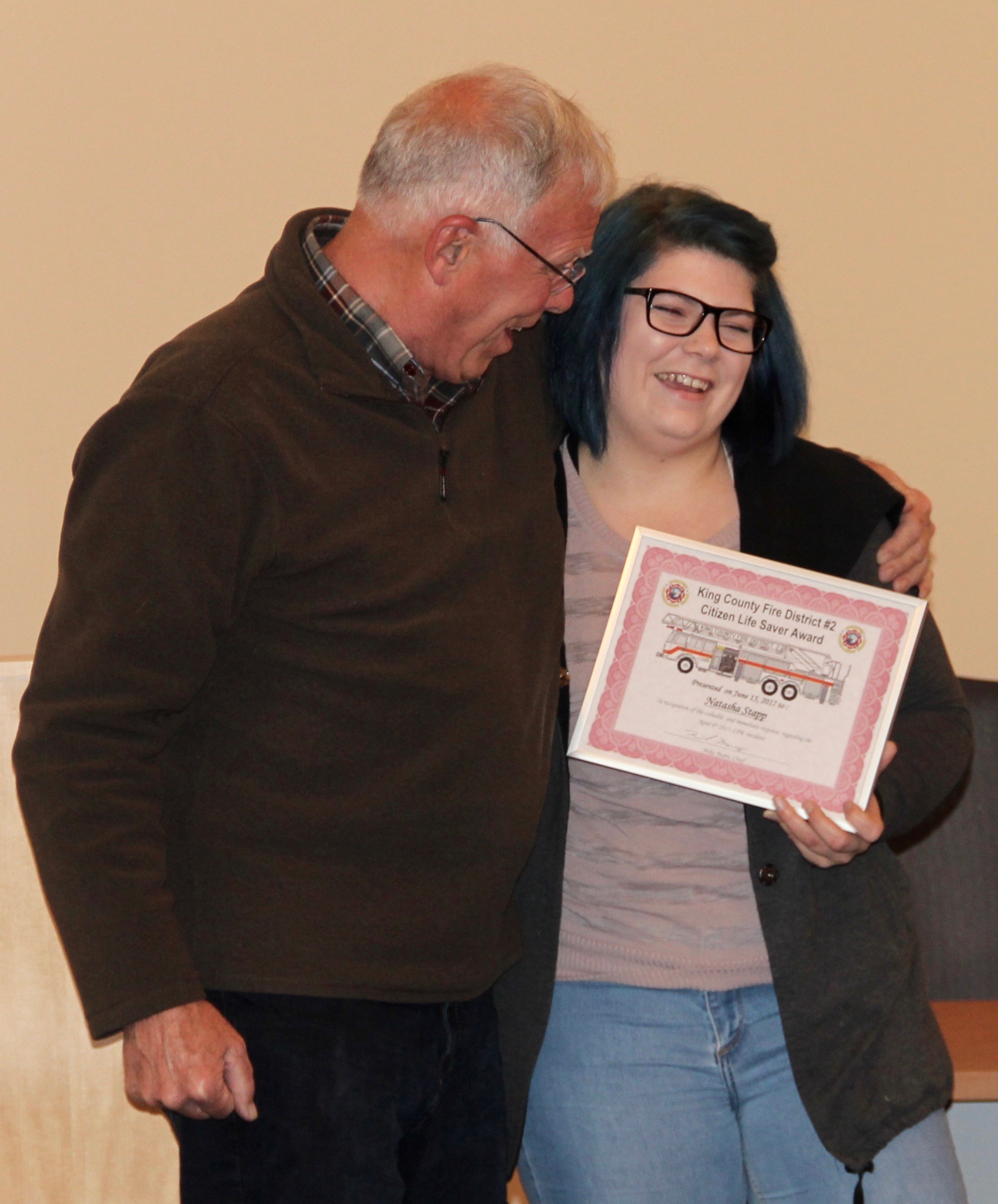 Chris Smith hugged Natasha Stapp at an awards recognition ceremony at the Burien Fire Department June 15. Her quick response in providing CPR to Smith after his collapse on the sidewalk in front of the Starbucks where she works on 148th and Ambaum earned her recognition by the fire department.