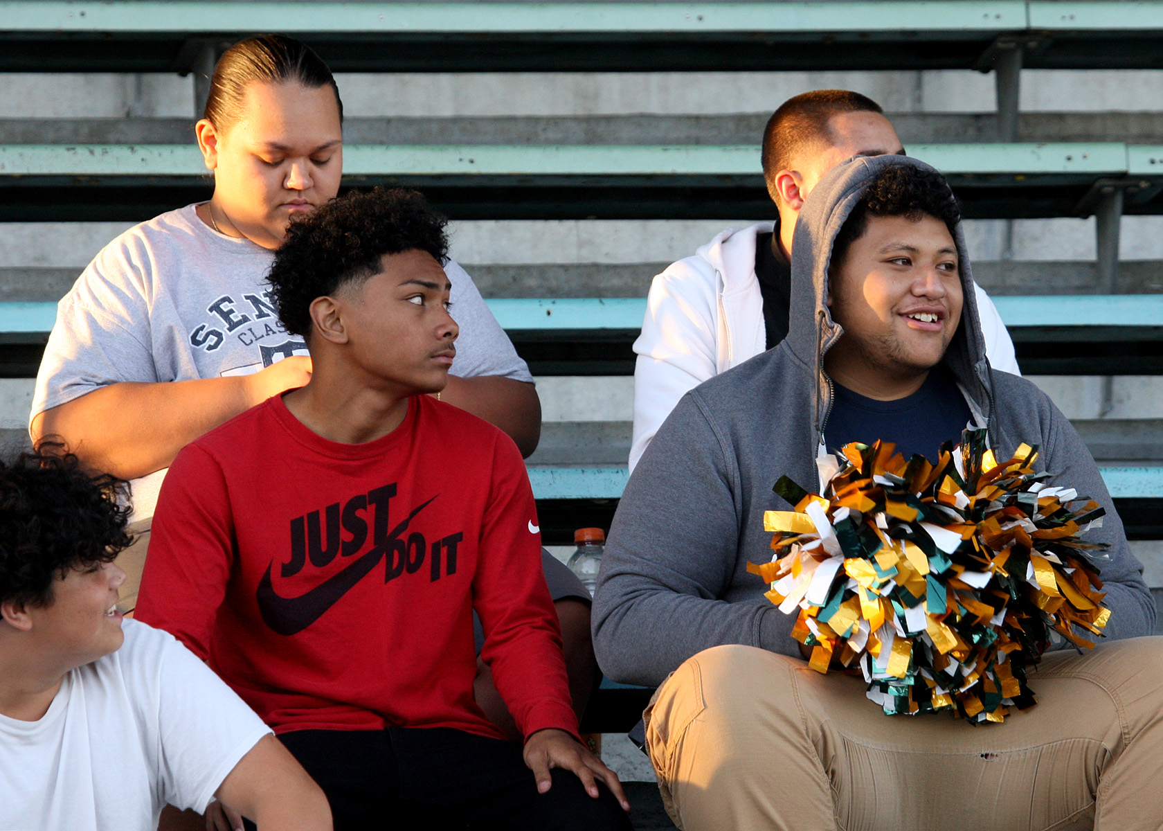 An Evergreen fan in the stands looks pleased that he got his hands on some pom poms. Photo by Kurt Howard