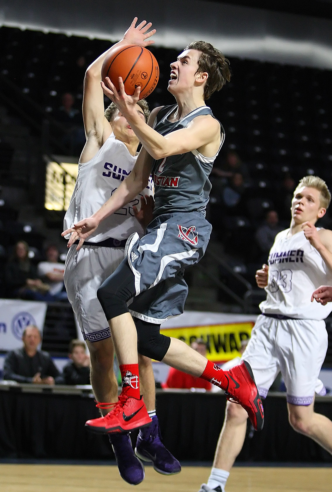 Jared Cattell of Seattle Christian scores as he drives to the hoop against Sumner’s AJ Andino.