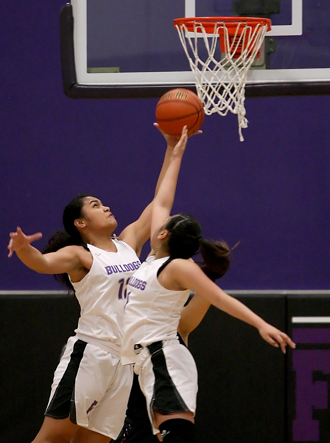 Sanela Musinovic and Amerie Pastores of Foster reach for a rebound under Lindbergh's basket.