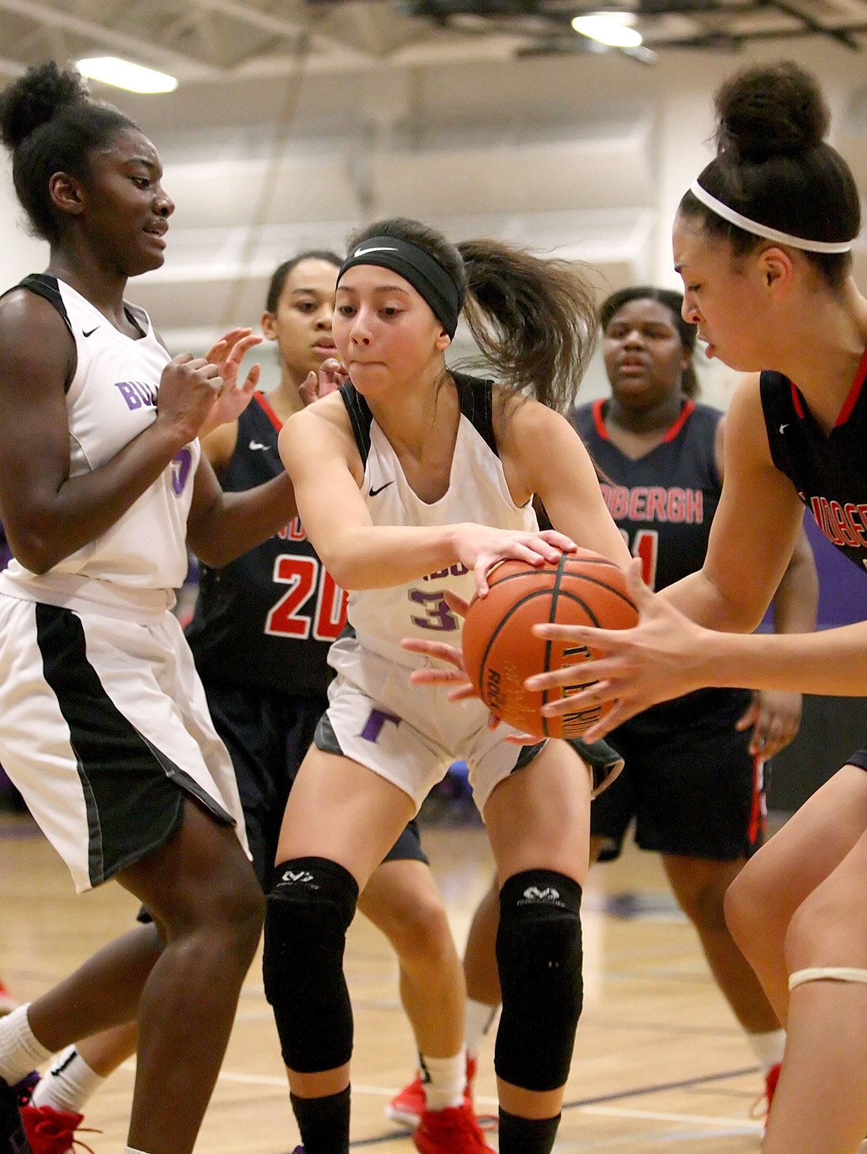 Makanalanii Montoya of Foster and Lindbergh's Elle Watts reach for the ball.