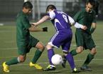 Kaelum Poulson of Foster (center) tries to gain control of the ball against Evergreen's Erik Lopez and Slidar Vasquez.
