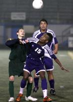 Simon Ghebremicael (15) of Foster stiff arms Evergreen's David Garcia to keep him away from the ball.