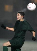 Evergreen's Kevin Ventura has water splatter from his head after heading the ball.