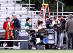 Local extras, including band members and cheerleaders wait their turn before the cameras.