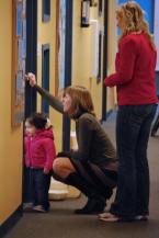 Center worker peer through the glass door at the children. Photo by Patrick Robinson