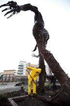 Artist Dan Dossman works on removing the sculpture. The Burien Town Square project is in the background. news01-B.jpg