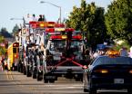 A school bus and tow trucks signal the end of the parade.
