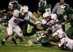 Running back Theo Mowatt of Evergreen is tackled by Foster's Kano Satele.