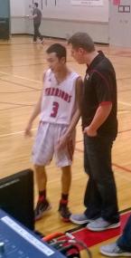Seattle Christian head coach Shaun DeYager gives instructions to Evan Toy in the game against Bellevue Christian.