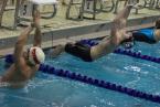 Swimmers diving off the wall for the start of the 100-yard backstroke at the 2A West Central District meet at the Hazen Pool in the Renton Highlands on Saturday