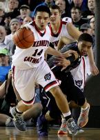 Michael Sasonoff of Kennedy Catholic moves the ball up court as Garfield's Terrell Brown reaches for the ball.