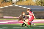 Warriors' keeper, Andrew Gesell, coming out of goal to make a save, with a Foster player, pressuring.