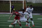 The Warriors' Cole Williams is trying to shield the ball from a Foster  defender.