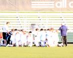Lancers' players kneeling and praying before state game against Shorewood  with head coach, Teddy Mitalas (left) and assistant, Doug Stamnes.